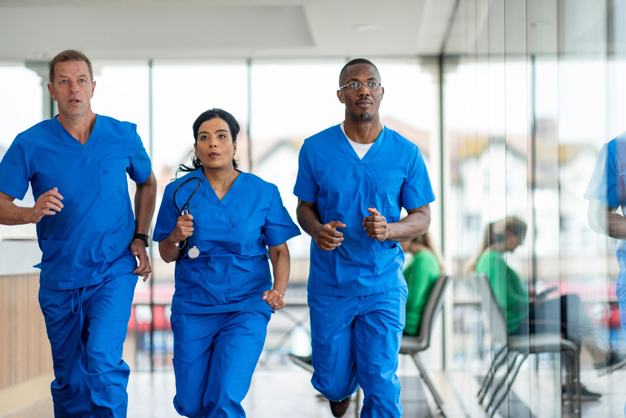 Healthcare professionals moving through a hospital corridor