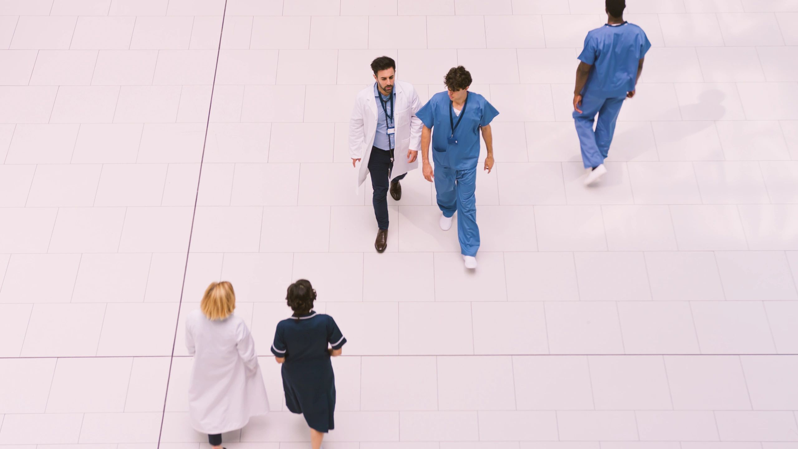 Medical staff moving through a modern hospital lobby