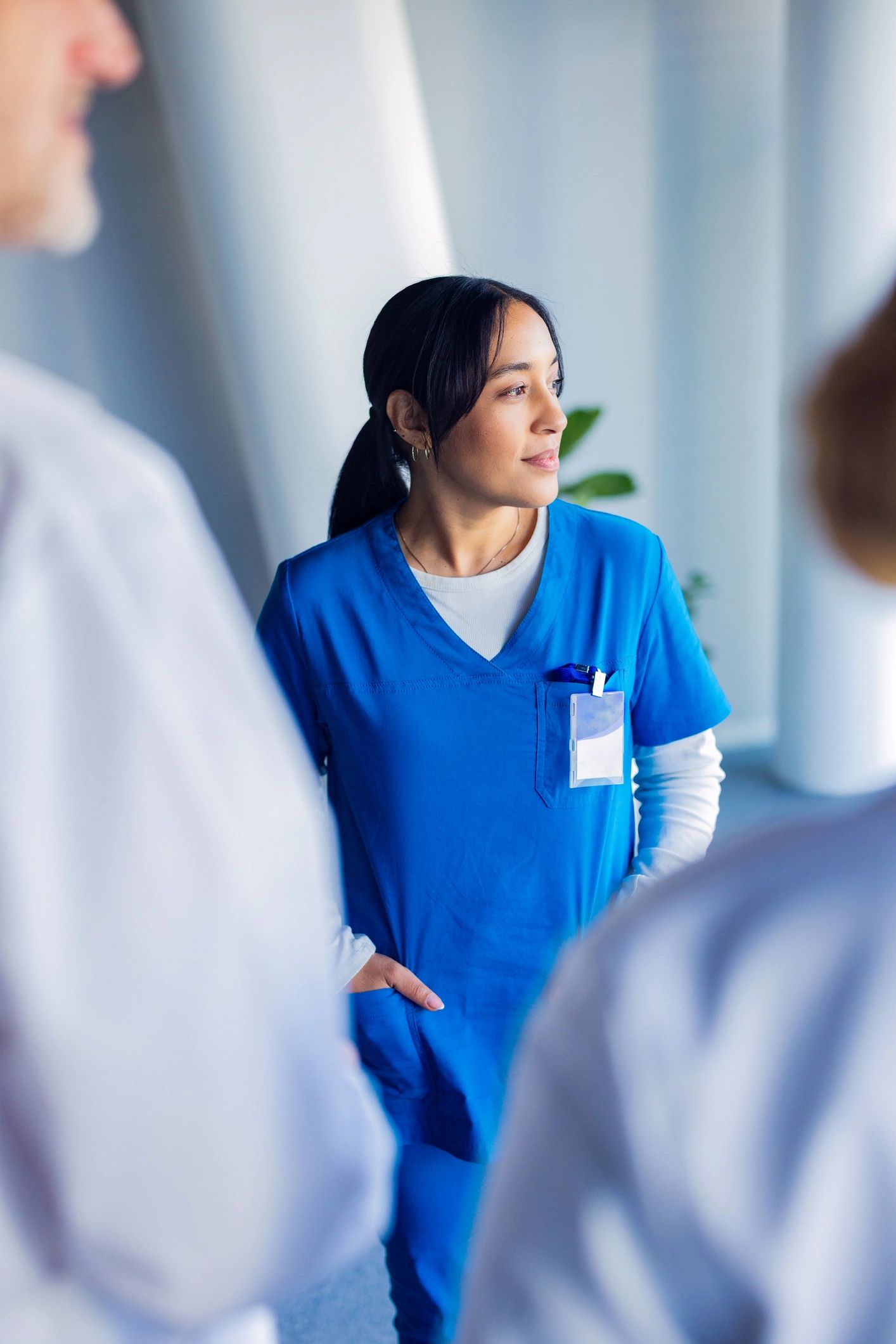 Nurse standing confidently with healthcare team nearby