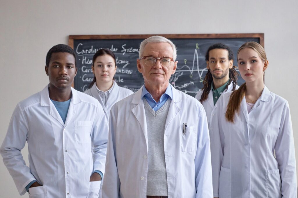 Portrait of Diverse Medical Team Standing with Professor in Classroom