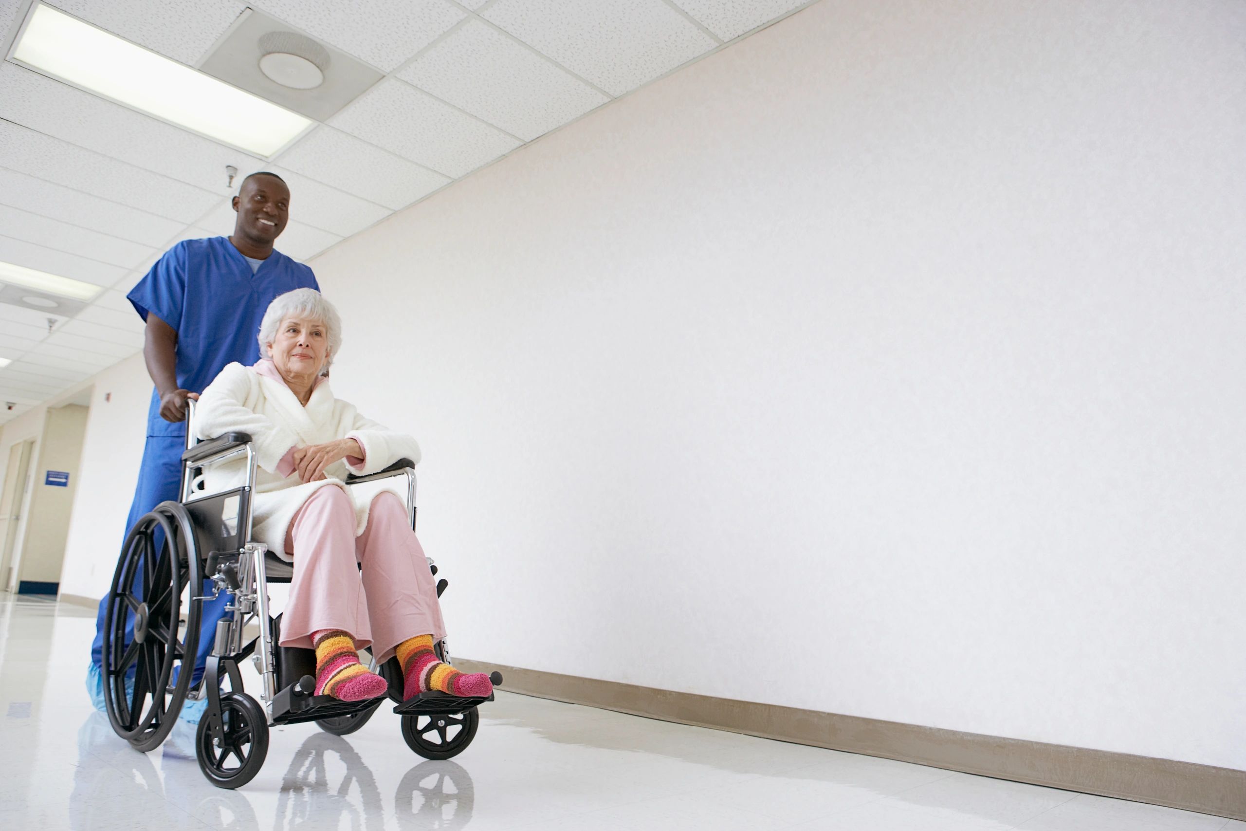 Nurse supporting patient transport in healthcare facility